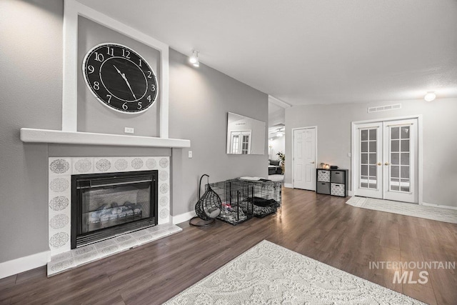 529 S State St, Nampa, ID 83686 - living area featuring wood finished floors, a tiled fireplace, french doors, and baseboards