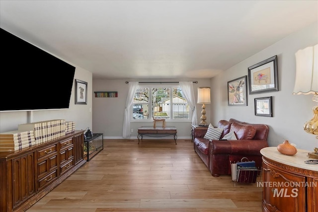 living room featuring light wood finished floors and baseboards