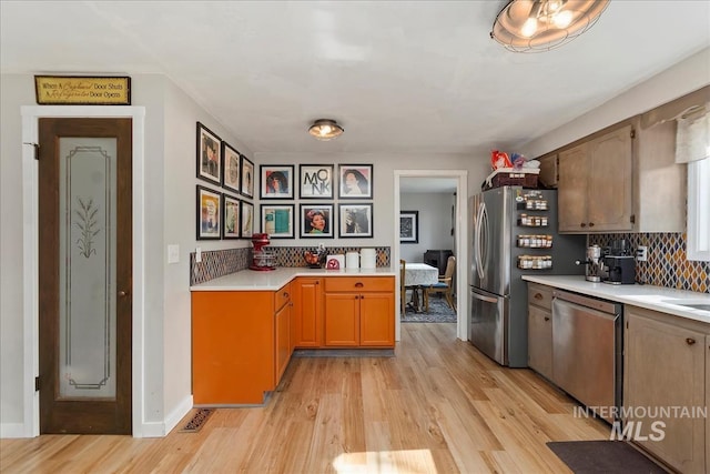 kitchen with visible vents, light wood-style flooring, tasteful backsplash, stainless steel appliances, and light countertops