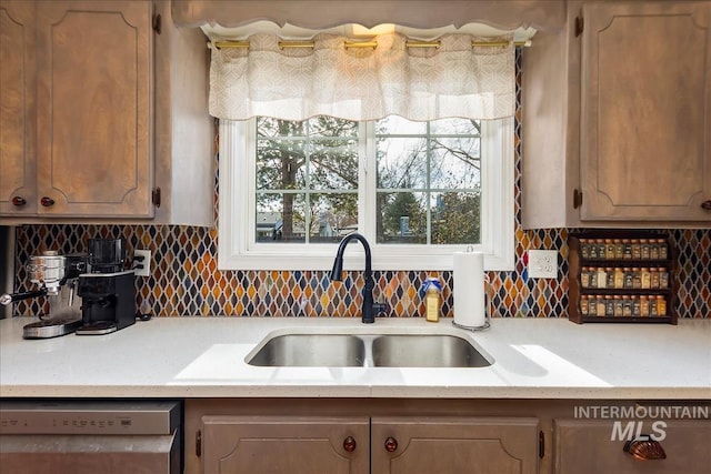 kitchen featuring a sink, tasteful backsplash, and dishwasher