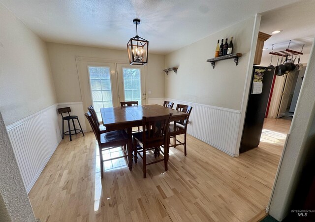 1223 Forest Rd, Winchester, ID 83555 - dining area with light wood finished floors, a wainscoted wall, and a chandelier