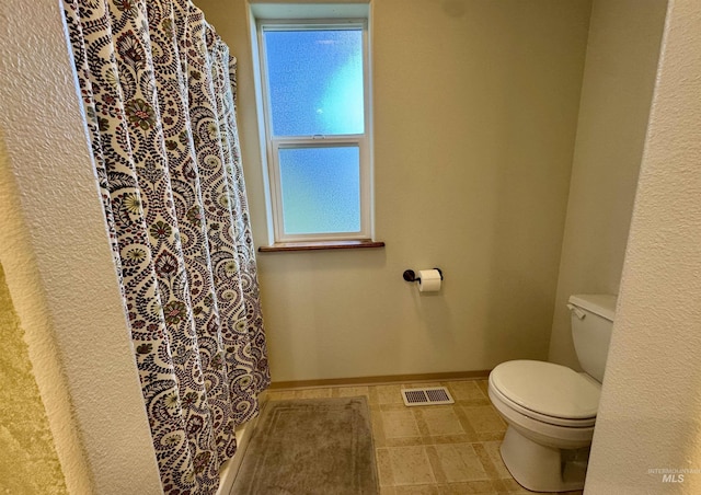 1223 Forest Rd, Winchester, ID 83555 - bathroom featuring toilet, baseboards, and a shower with curtain