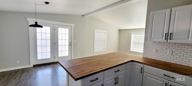 kitchen featuring vaulted ceiling with beams, pendant lighting, dark hardwood / wood-style flooring, butcher block countertops, and white cabinetry