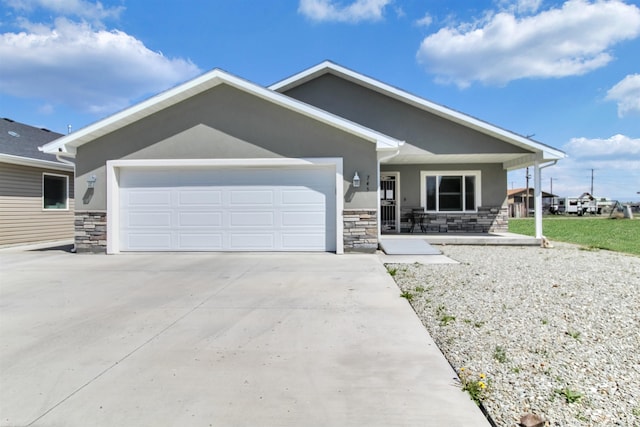 view of front of house featuring stucco siding, a garage, concrete driveway, and stone siding