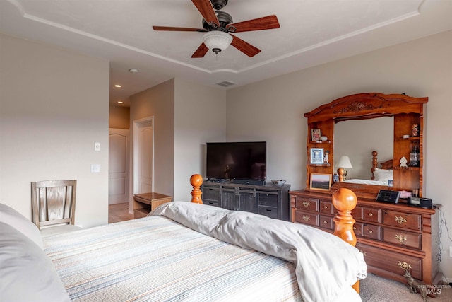 carpeted bedroom featuring a tray ceiling and ceiling fan