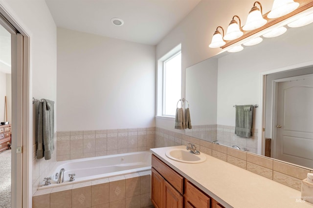 bathroom with vanity and tiled bath