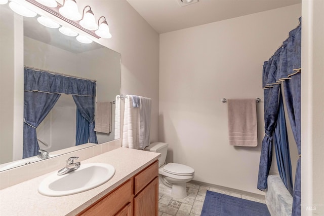 bathroom featuring curtained shower, vanity, and toilet