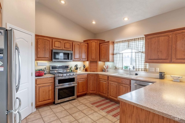 kitchen featuring light tile patterned flooring, appliances with stainless steel finishes, vaulted ceiling, and sink