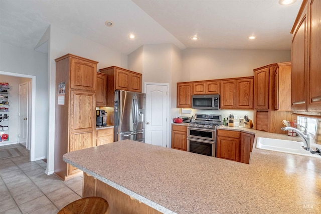 kitchen with kitchen peninsula, stainless steel appliances, sink, light tile patterned floors, and high vaulted ceiling