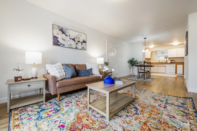 living area featuring baseboards and light wood finished floors