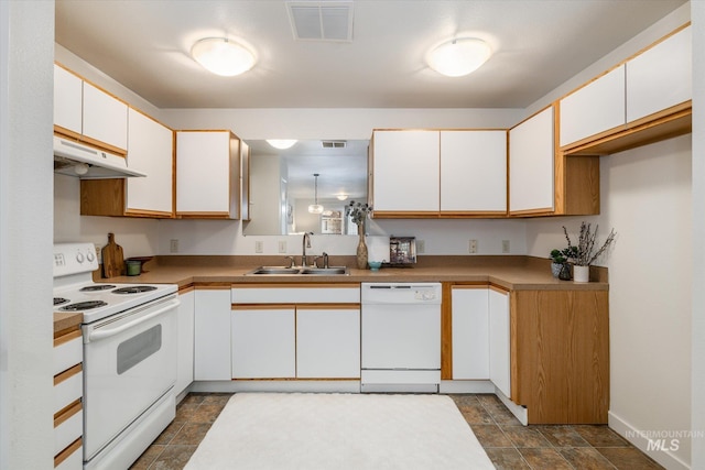 kitchen with white appliances, visible vents, a sink, under cabinet range hood, and white cabinetry