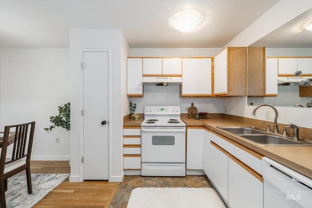 kitchen with under cabinet range hood, white appliances, white cabinetry, and a sink