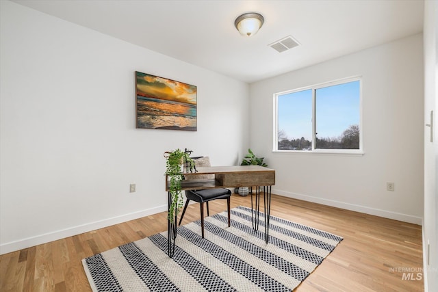 office area with visible vents, baseboards, and light wood finished floors