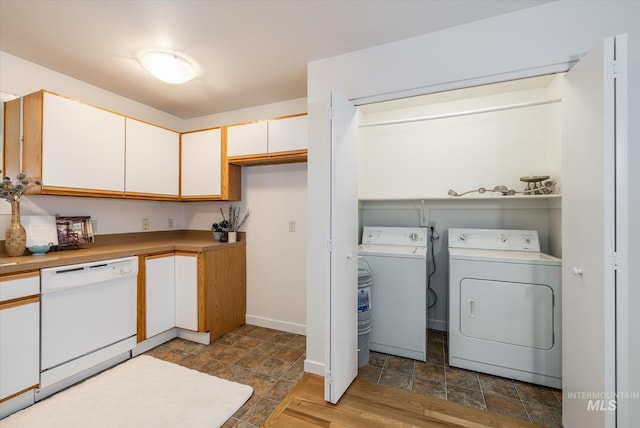 laundry area featuring stone finish flooring, baseboards, separate washer and dryer, and laundry area