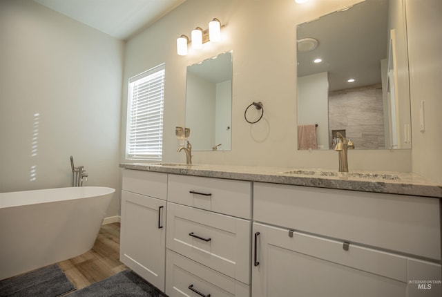 bathroom featuring hardwood / wood-style flooring, vanity, and a washtub