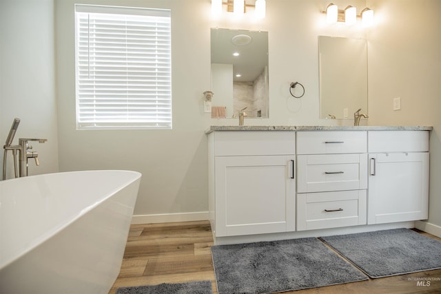 bathroom featuring vanity, wood-type flooring, and a bathtub