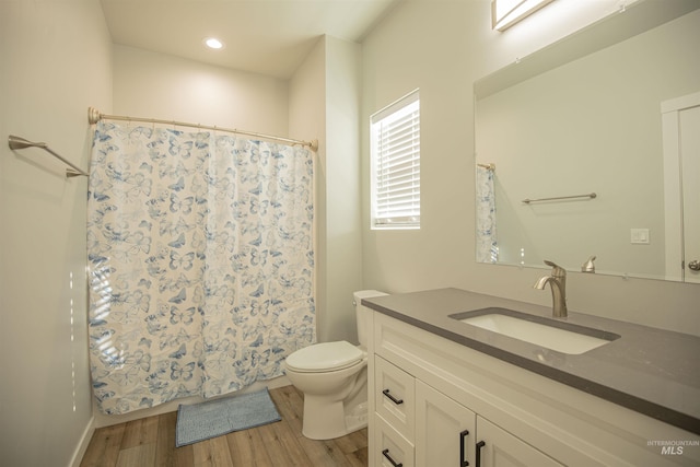 bathroom with a shower with curtain, vanity, hardwood / wood-style floors, and toilet