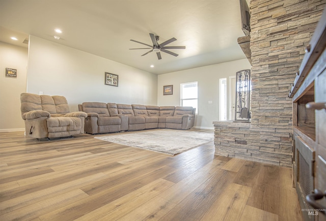 living room with ceiling fan and light wood-type flooring