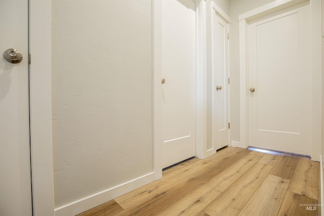 corridor with light hardwood / wood-style floors