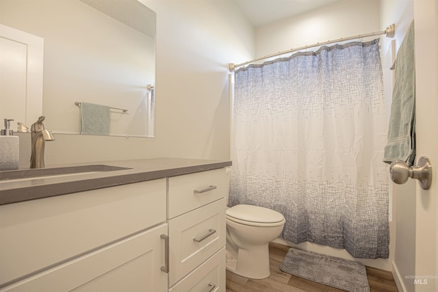 bathroom featuring vanity, toilet, curtained shower, and hardwood / wood-style floors