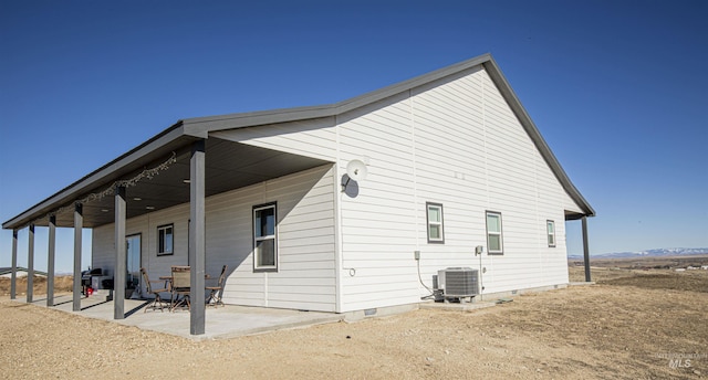 back of property with central AC and a patio