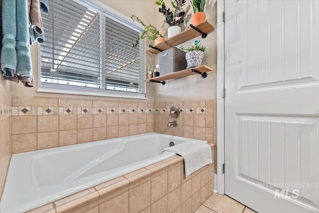 bathroom featuring a relaxing tiled tub and tile patterned flooring