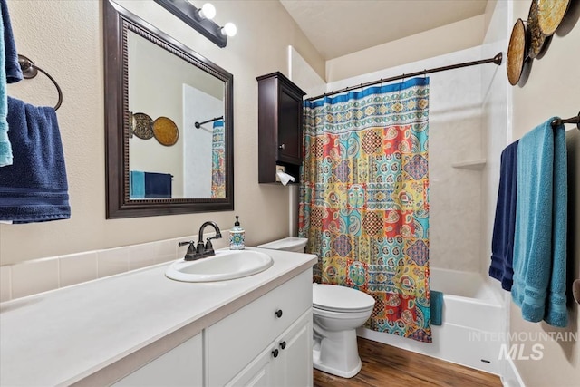 full bathroom with hardwood / wood-style flooring, vanity, toilet, and shower / tub combo