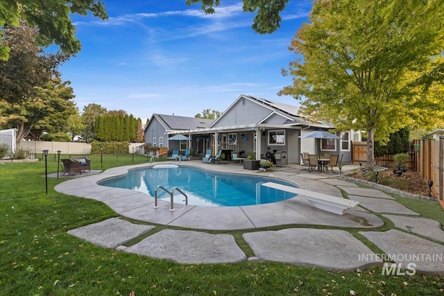 view of pool with a yard and a patio area