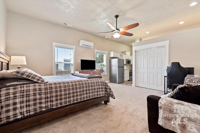 bedroom featuring a wall mounted AC, stainless steel fridge, ceiling fan, light carpet, and a textured ceiling