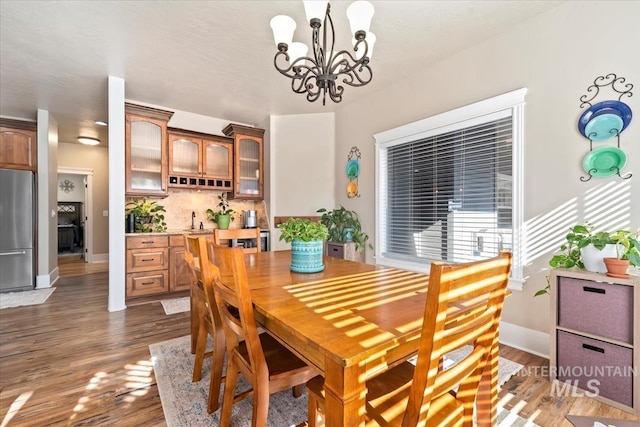 dining room featuring dark hardwood / wood-style floors, sink, and an inviting chandelier