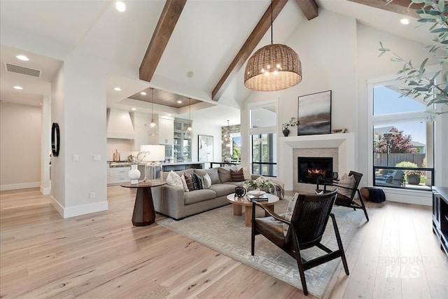 2685 N Fruniz Ave, Eagle, ID 83616 - living area with high vaulted ceiling, light wood-style floors, beamed ceiling, a glass covered fireplace, and recessed lighting