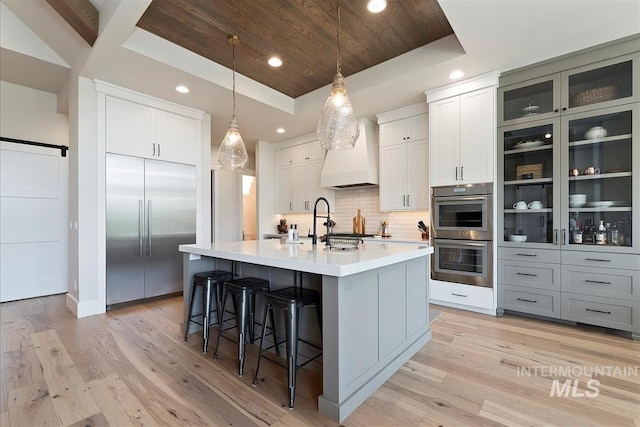 2685 N Fruniz Ave, Eagle, ID 83616 - kitchen with appliances with stainless steel finishes, wooden ceiling, light countertops, a breakfast bar area, and tasteful backsplash