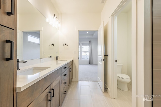 bathroom with tile patterned flooring, vanity, and toilet