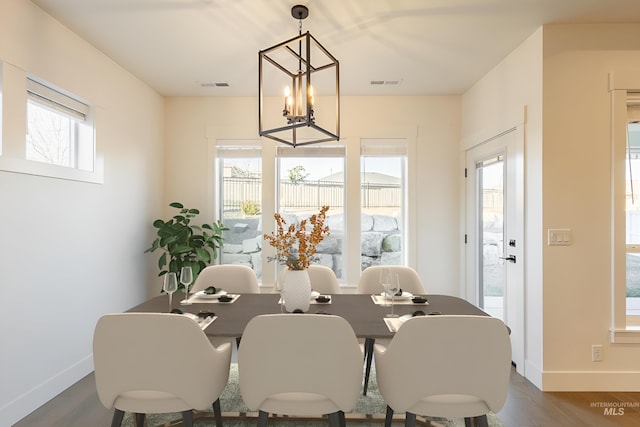 dining area with a notable chandelier and hardwood / wood-style flooring