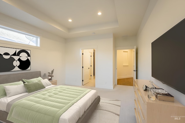 carpeted bedroom featuring a raised ceiling