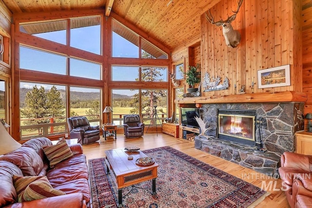 2510 Price Valley Rd, New Meadows, ID 83654 - living area with high vaulted ceiling, a fireplace, hardwood / wood-style floors, wooden walls, and beamed ceiling