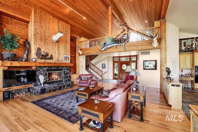 2510 Price Valley Rd, New Meadows, ID 83654 - living area with stairs, hardwood / wood-style floors, a stone fireplace, high vaulted ceiling, and wooden ceiling with exposed beams