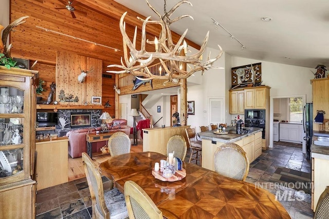 2510 Price Valley Rd, New Meadows, ID 83654 - dining space featuring stone tile flooring, high vaulted ceiling, a chandelier, and rail lighting