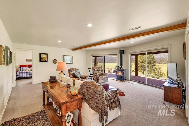 2510 Price Valley Rd, New Meadows, ID 83654 - carpeted living area with a wood stove, beamed ceiling, recessed lighting, and baseboards