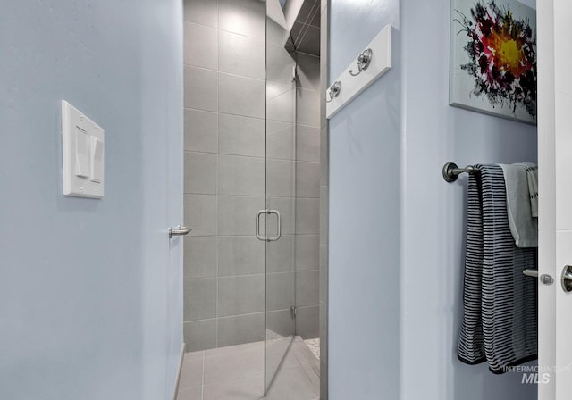 bathroom with tile patterned flooring and a shower with shower door