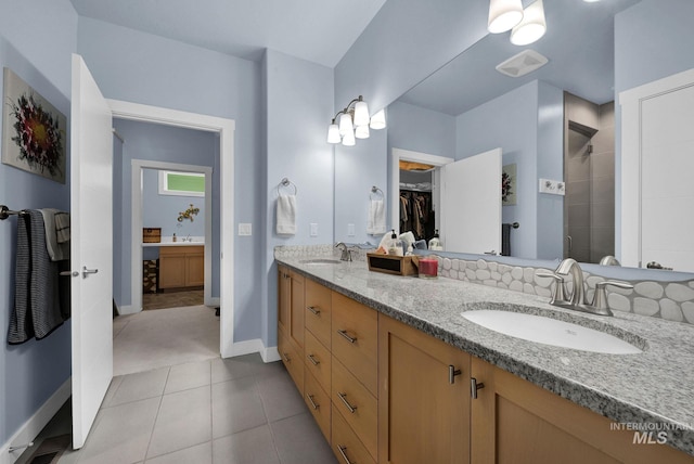 bathroom featuring tile patterned flooring, a shower with shower door, and vanity