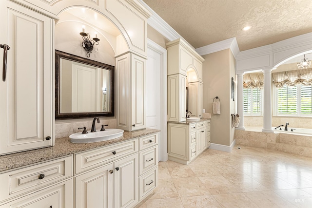 1137 N Cobblestone Way, Eagle, ID 83616 - bathroom with ornate columns, two vanities, a garden tub, a textured ceiling, and ornamental molding