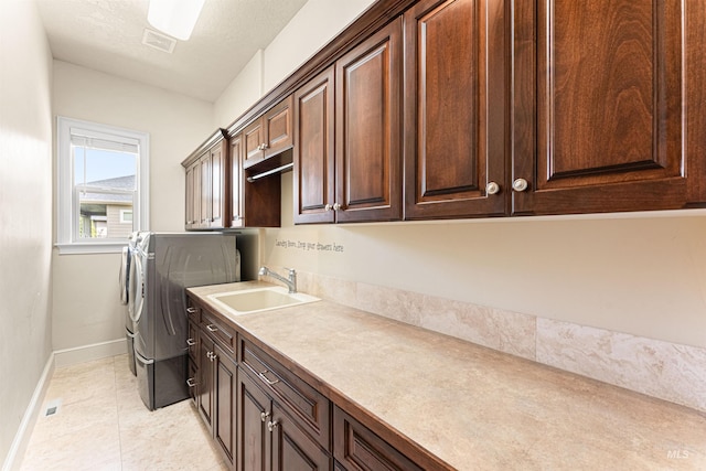 1137 N Cobblestone Way, Eagle, ID 83616 - laundry area with washer and clothes dryer, cabinet space, baseboards, and light tile patterned floors