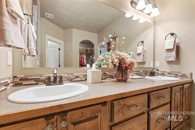 full bathroom featuring double vanity, visible vents, and a sink