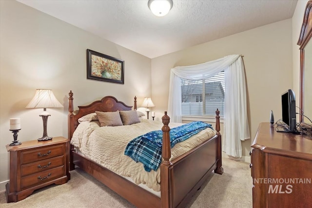 bedroom featuring light carpet, a textured ceiling, and baseboards