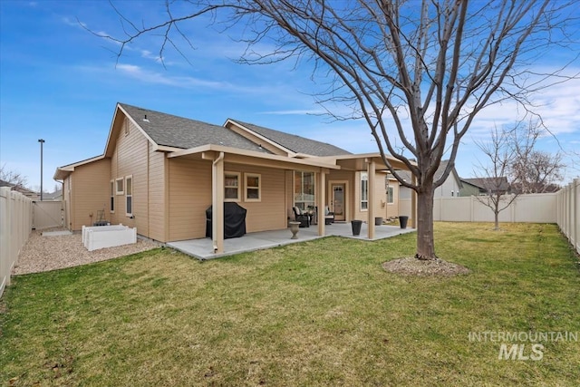 rear view of house with a yard, a patio, a fenced backyard, and a shingled roof