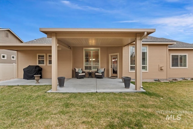 rear view of property featuring fence, a lawn, and a patio area