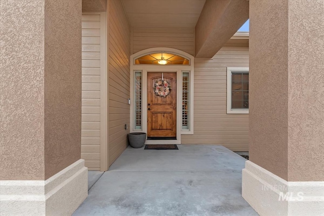 entrance to property featuring stucco siding