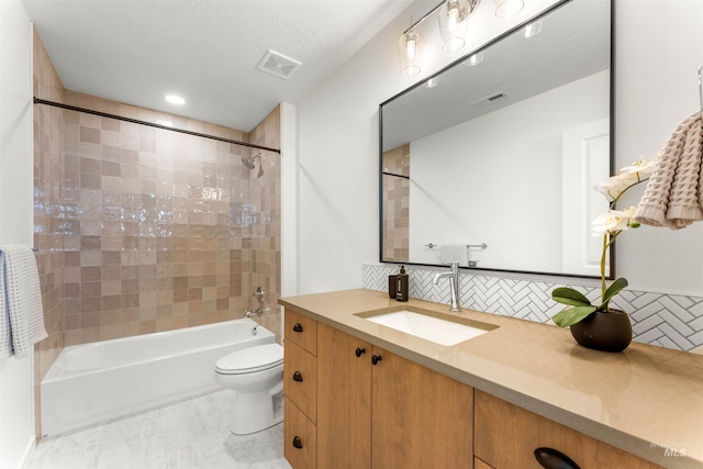 full bathroom featuring tiled shower / bath, decorative backsplash, a textured ceiling, toilet, and vanity