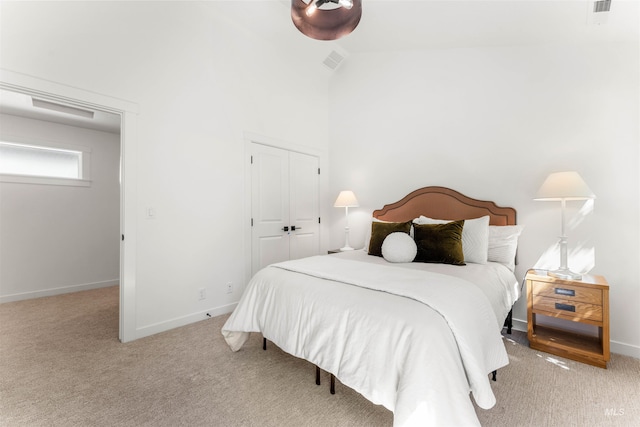 carpeted bedroom with lofted ceiling and a closet